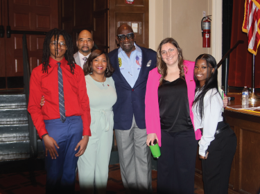students, board members, and superintendent standing with Chris Gardner